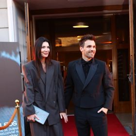 Monika oblékla tmavě šedý oversize kalhotový kostýmek doplněný o psaníčko Yves Saint Laurent.