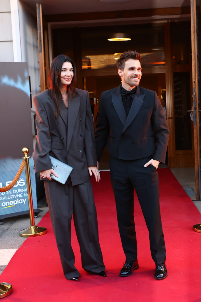 Monika oblékla tmavě šedý oversize kalhotový kostýmek doplněný o psaníčko Yves Saint Laurent.