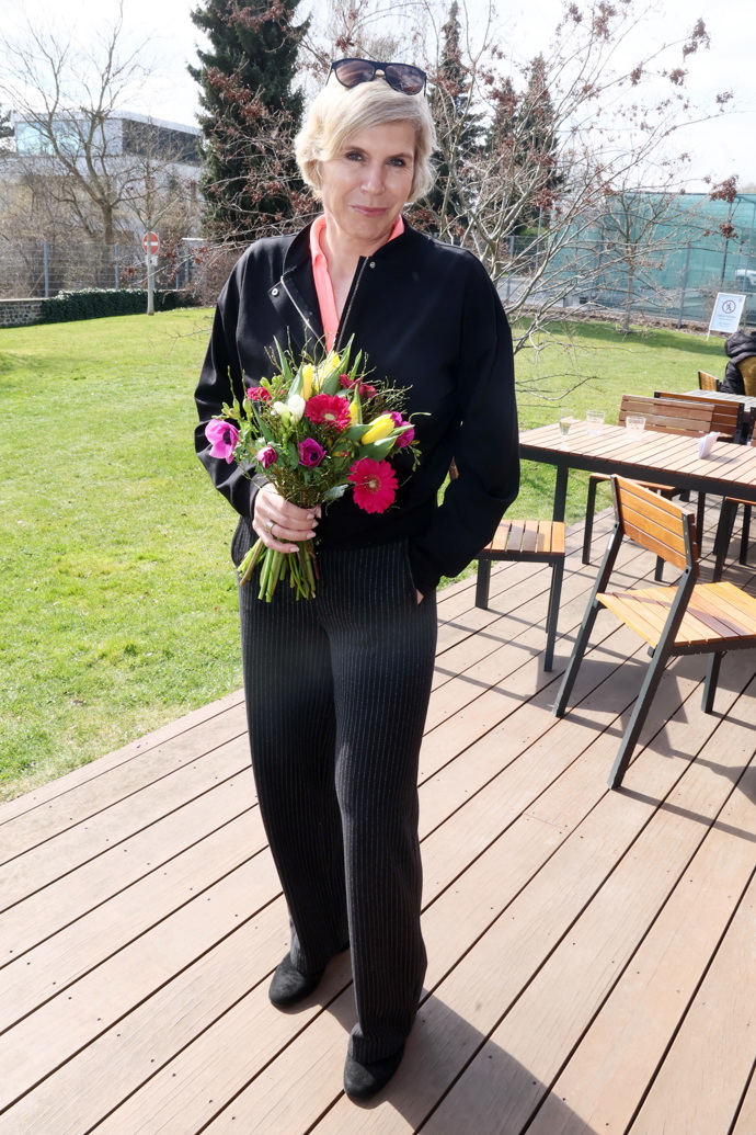 Oblékla černé žebrované kalhoty, černou mikinu a broskvové tričko s výstřihem do V. 