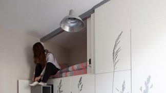 Ze skříně se vysouvá úložný prostro, který zároveň slouží jako schody k posteli.
