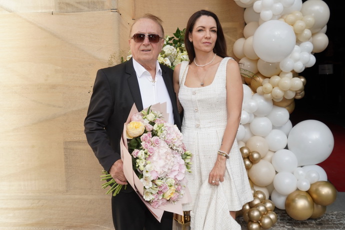 Zatímco hudebník vsadil na černobílou klasiku, jeho manželka oblékla elegantní krémové mini šaty s trendy hranatým výstřihem.