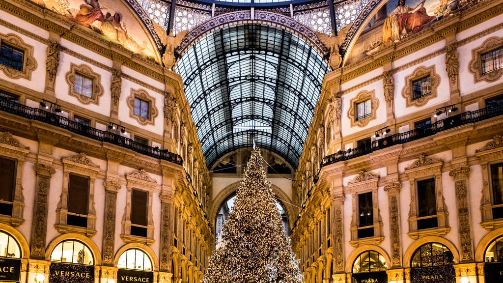 Galleria Vittorio Emanuele II: Startovní čára pro Pradu
Milánskou katedrálu Duomo a budovu slavné opery La Scala spojuje nejstarší obchodní dům v celé Itálii. Architekt Giuseppe Mengoni dokončil tuto nákupní pasáž se čtyřmi křídly a skleněnou kopulí v roce 1867 a město Milán se rozhodlo ji pojmenovat po prvním králi sjednocené Itálie, Viktorovi Emanuelovi II. V bohatě zdobené průchozí galerii najdete ty nejluxusnější značky, jako jsou Prada, Versace nebo Gucci. Zdejší obchod Prady byl dokonce teprve druhý, který značka kdy otevřela.
Výlohy obchodů jsou vždy dotažené do posledního detailu a často se obměňují. Značky, které v galerii chtějí mít svůj obchod, musejí ale dodržovat jistá pravidla. Například název obchodu musí být napsaný zlatým písmem v černém poli, aby se zachoval původní jednotný design. Kromě obchodů zde najdete také proslulé milánské restaurace jako Biffi nebo Savini. V prosinci zdobí střed galerie vánoční strom, který byl v minulých letech osázený až 35 tisíci světýlky. Při návštěvě pasáže si také rozhodně nenechte ujít příležitost podívat se i na střechu.
Galleria Vittorio Emanuele II: Startovní čára pro Pradu
Milánskou katedrálu Duomo a budovu slavné opery La Scala spojuje nejstarší obchodní dům v celé Itálii. Architekt Giuseppe Mengoni dokončil tuto nákupní pasáž se čtyřmi křídly a skleněnou kopulí v roce 1867 a město Milán se rozhodlo ji pojmenovat po prvním králi sjednocené Itálie, Viktorovi Emanuelovi II. V bohatě zdobené průchozí galerii najdete ty nejluxusnější značky, jako jsou Prada, Versace nebo Gucci. Zdejší obchod Prady byl dokonce teprve druhý, který značka kdy otevřela.
Výlohy obchodů jsou vždy dotažené do posledního detailu a často se obměňují. Značky, které v galerii chtějí mít svůj obchod, musejí ale dodržovat jistá pravidla. Například název obchodu musí být napsaný zlatým písmem v černém poli, aby se zachoval původní jednotný design. Kromě obchodů zde najdete také proslulé milánské restaurace jako Biffi nebo Savini. V prosinci zdobí střed galerie vánoční strom, který byl v minulých letech osázený až 35 tisíci světýlky. Při návštěvě pasáže si také rozhodně nenechte ujít příležitost podívat se i na střechu.