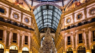 Galleria Vittorio Emanuele II: Startovní čára pro Pradu

Milánskou katedrálu Duomo a budovu slavné opery La Scala spojuje nejstarší obchodní dům v celé Itálii. Architekt Giuseppe Mengoni dokončil tuto nákupní pasáž se čtyřmi křídly a skleněnou kopulí v roce 1867 a město Milán se rozhodlo ji pojmenovat po prvním králi sjednocené Itálie, Viktorovi Emanuelovi II. V bohatě zdobené průchozí galerii najdete ty nejluxusnější značky, jako jsou Prada, Versace nebo Gucci. Zdejší obchod Prady byl dokonce teprve druhý, který značka kdy otevřela.

Výlohy obchodů jsou vždy dotažené do posledního detailu a často se obměňují. Značky, které v galerii chtějí mít svůj obchod, musejí ale dodržovat jistá pravidla. Například název obchodu musí být napsaný zlatým písmem v černém poli, aby se zachoval původní jednotný design. Kromě obchodů zde najdete také proslulé milánské restaurace jako Biffi nebo Savini. V prosinci zdobí střed galerie vánoční strom, který byl v minulých letech osázený až 35 tisíci světýlky. Při návštěvě pasáže si také rozhodně nenechte ujít příležitost podívat se i na střechu.
