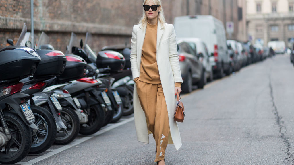 Důkaz, že tepláková souprava jde zkombinovat i do elegantního outfitu s kabátem, kabelkou a balerínami