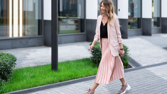 Žena v trendy teniskách a sukni