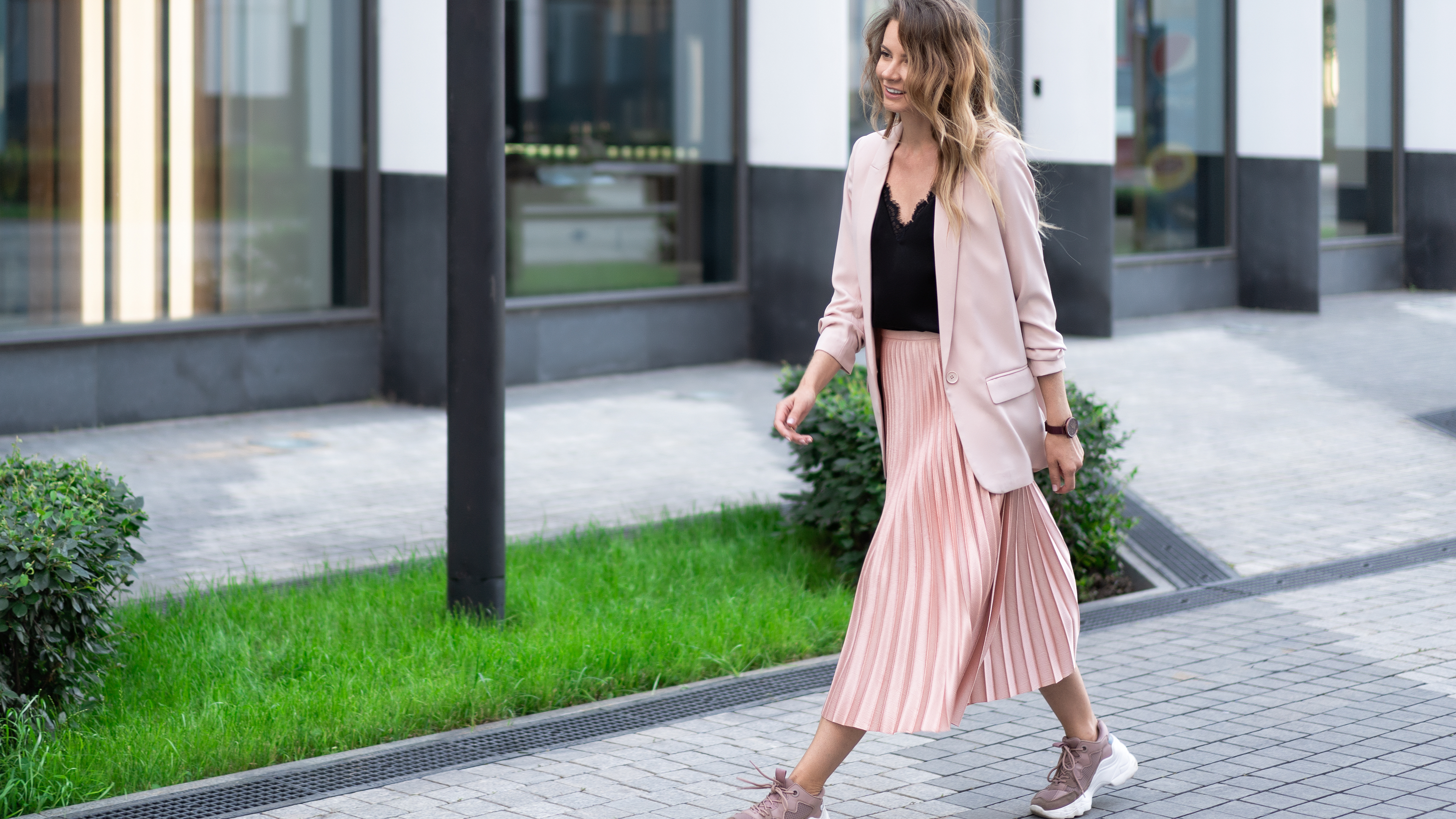Žena v trendy teniskách a sukni