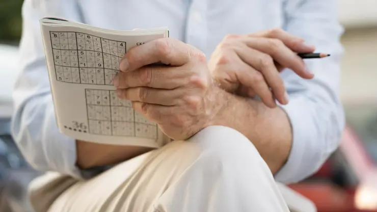 Muž hrající sudoku.