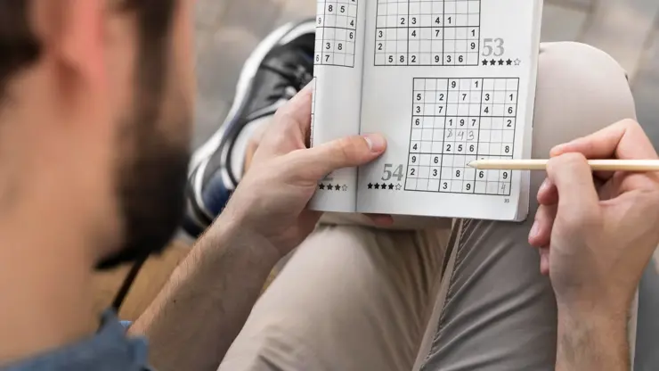 Muž hrající sudoku.