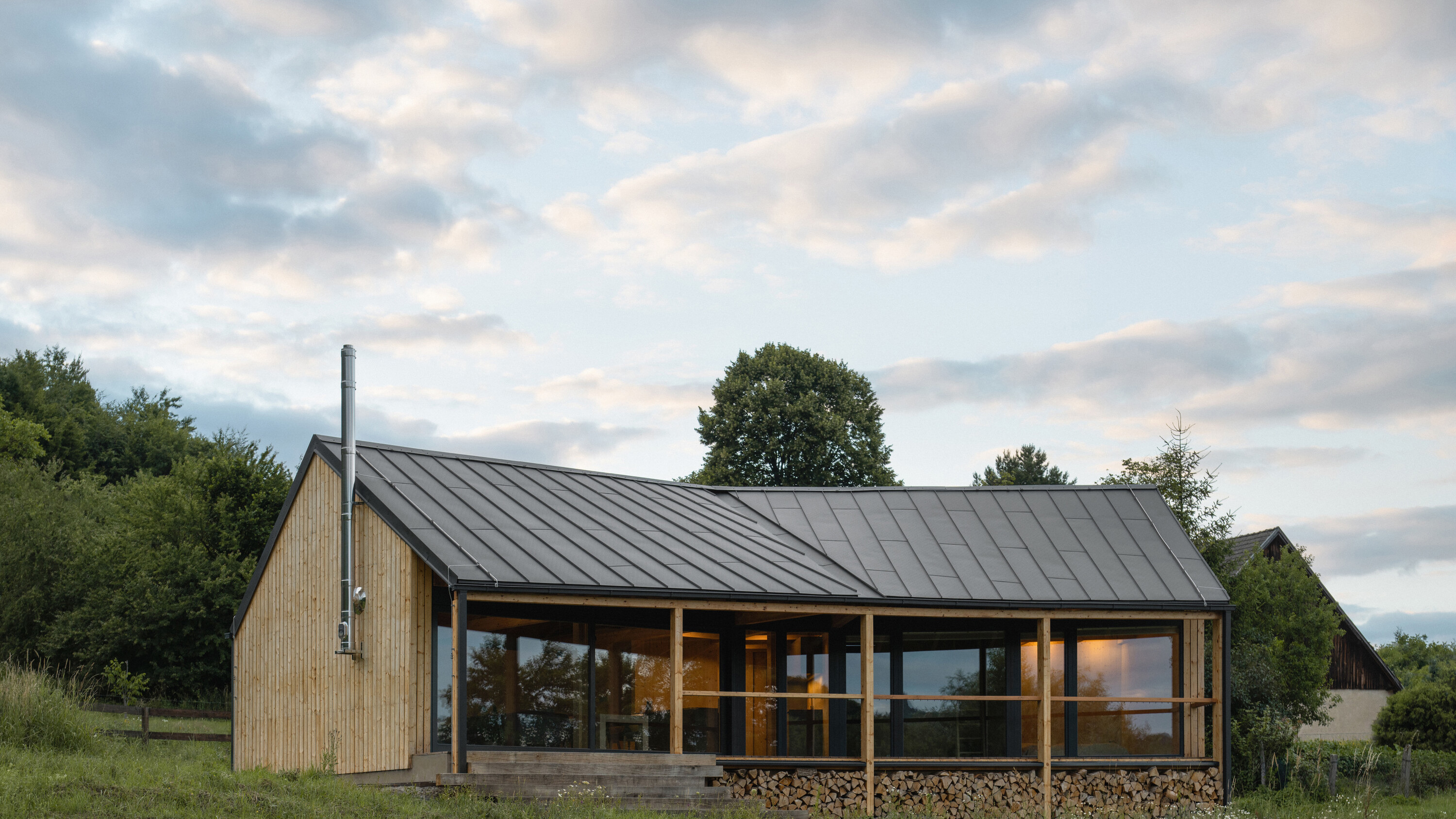 Na kraji Hrubé Skály vyrostl víkendový dům, který přirozeně zapadá do krajiny Českého ráje. Citlivě kombinuje tradiční prvky s moderní architekturou a nabízí klidné místo k odpočinku s výhledem na zříceninu hradu Trosky.
