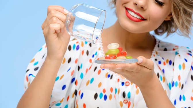 žena s barevnými vitaminy na talířku
