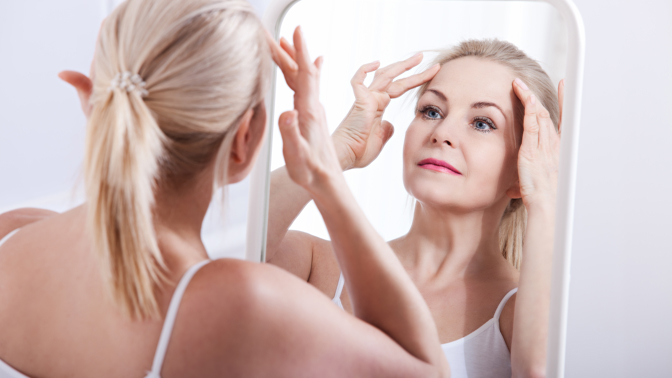 žena 40+ před zrcadlem si prohlíží své vrásky