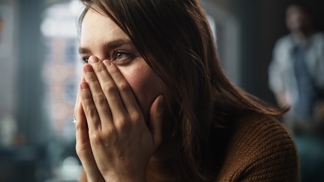 Žena zakrývající si tvář do dlaní