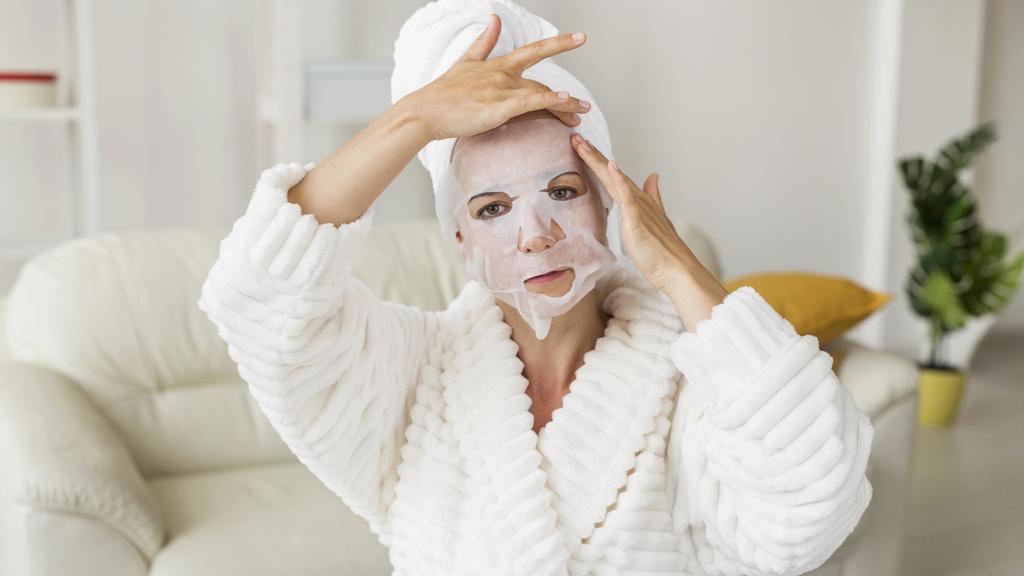 žena aplikuje pleťovou masku na obličej žena aplikuje pleťovou masku na obličej