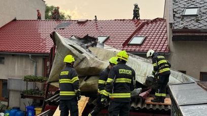 FOTO: Hasiči přímo na střeše bojují se srolovanými plechy, které utrhl silný vítr.