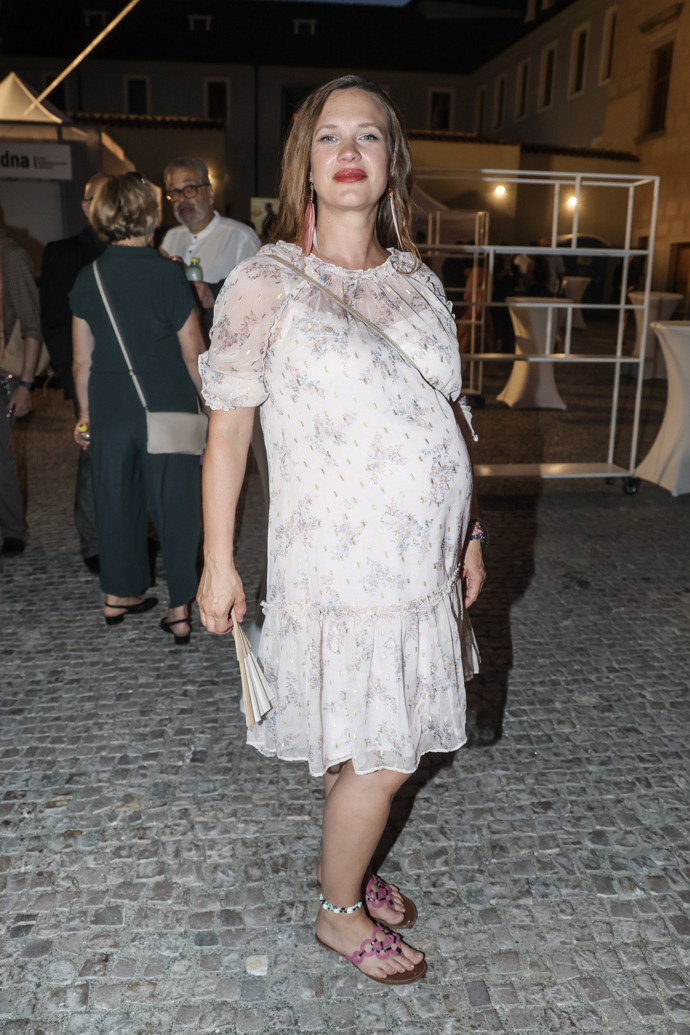 Herečka zkombinovala elegantnější šaty ke kolenům s peříčkovými náušnicemi a pestrobarevnými sandály v boho duchu.