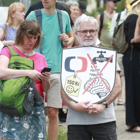 Účastník protestu drží štít s grafikou varující před tím, aby politici utáhli České televizi finanční kohoutky.