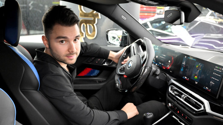 Adam Kajumi ve svém BMW.