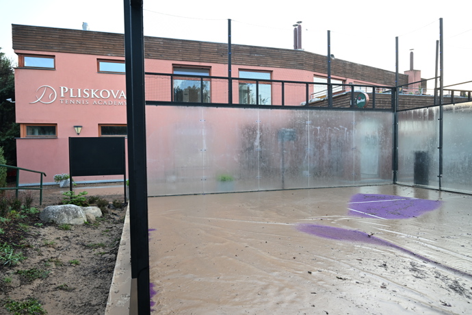 Luxusní kurty na padel s logem akademie Karolíny Plíškové jsou po včerejší potopě pod nánosem hnědé břečky.