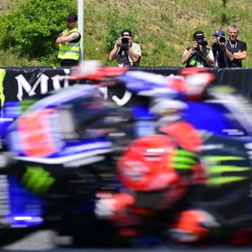 Mezi ostatními fotografy u trati, kde se v rychlosti míhají závodní stroje.
