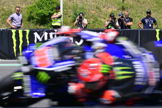 Mezi ostatními fotografy u trati, kde se v rychlosti míhají závodní stroje.