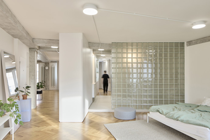 Do středu bytu architekti umístili jediný kompaktní nábytkový blok, který se stal hlavním organizátorem prostoru. Jeho mírné pootočení vytvořilo několik samostatně fungujících zón. 