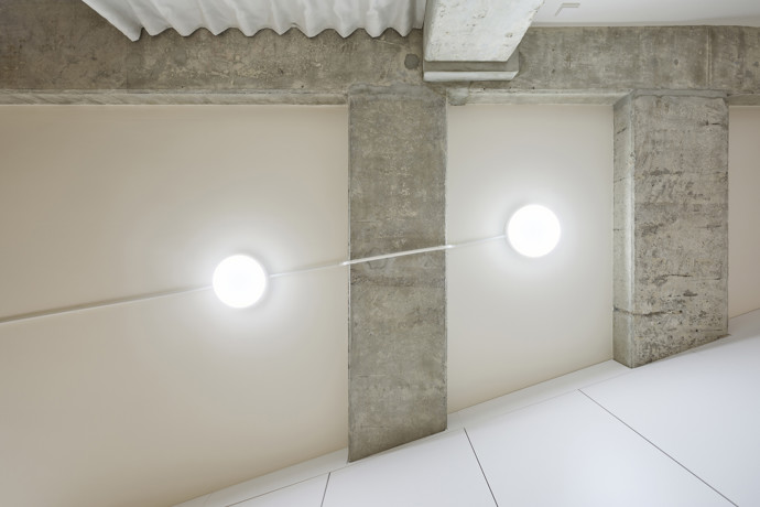 Celkovou kompozici doplňuje jednoduchý bílý vestavěný nábytek, několik ikonických designových kusů, pokojové rostliny a osobní předměty obyvatel, které prostoru dodávají přirozenost.