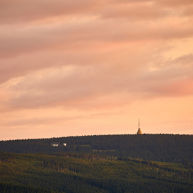 Západ slunce nad krkonošskými hřebeny vytváří fotogenické scenerie s typickými horskými siluetami.