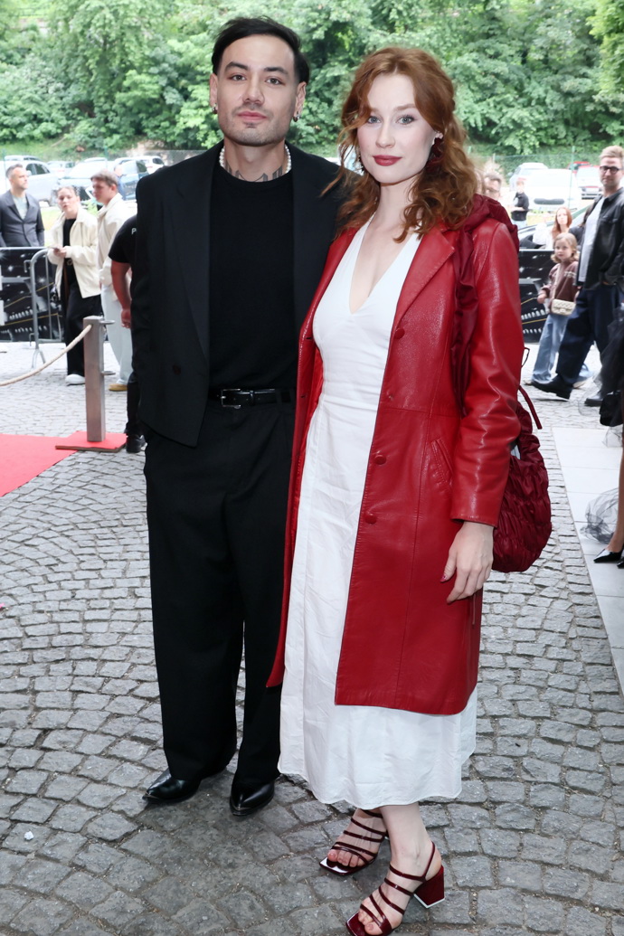 Natálie Halouzková v doprovodu Renneho Danga. Natálie oblékla bílé šaty a rudý kožený kabát. 