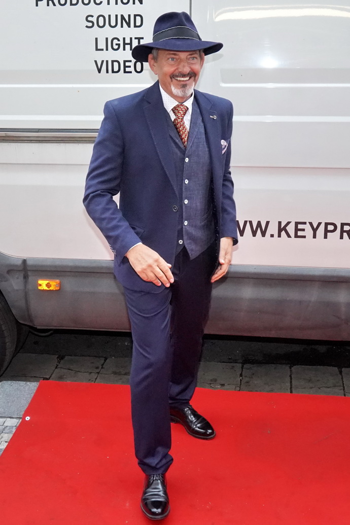 Otakar Brousek mladší přišel v tmavě modrém obleku, kterému nechyběly elegantní vestička ani klobouk. Kravatu zvolil v kontrastní barvě.