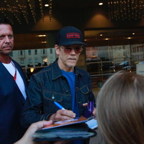 Kevin Bacon ochotně podepisoval fotky fanouškům před hotelem.