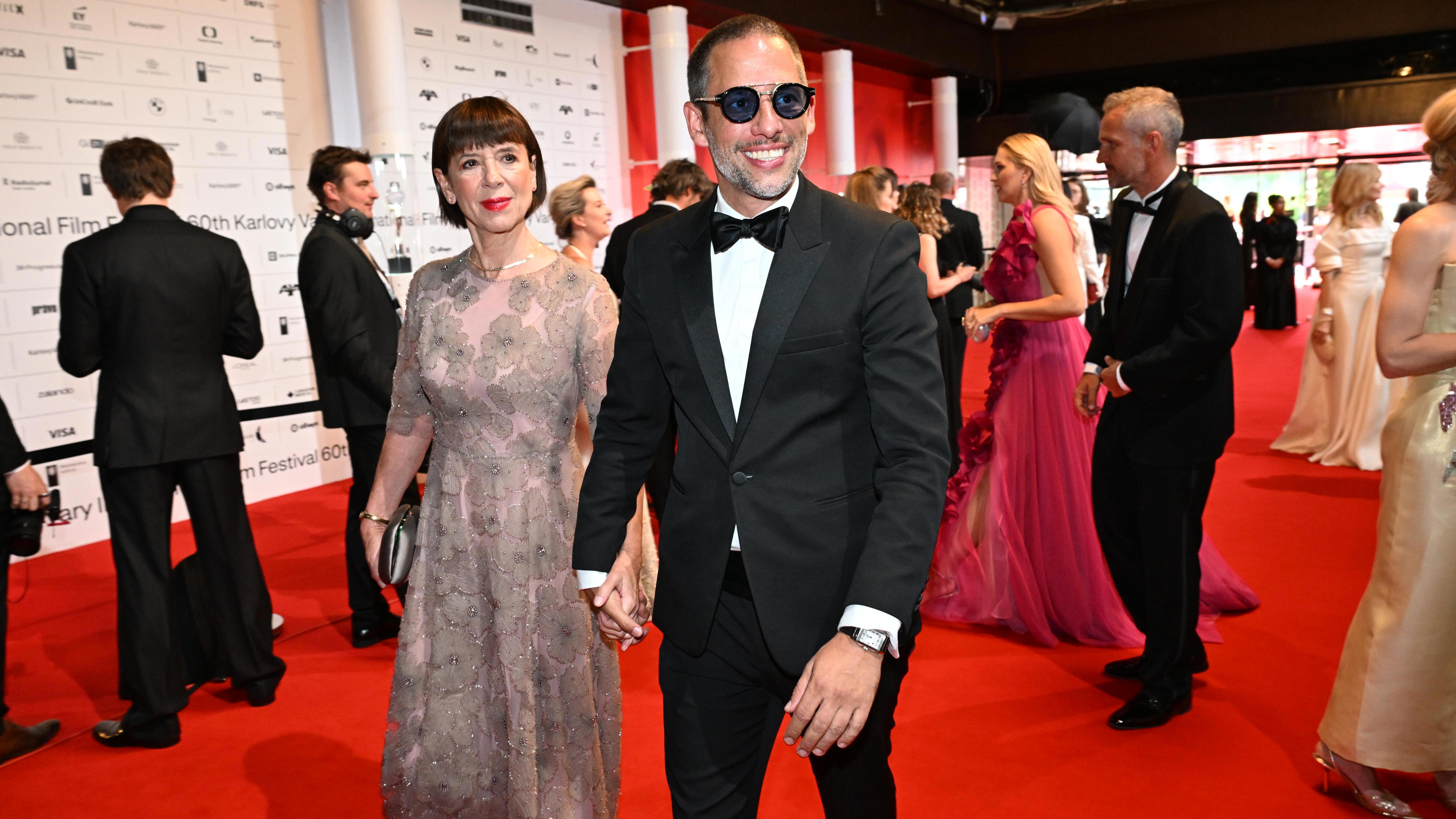 Andrea Bartošková na zahájení KVIFF po boku syna. Loňskou černou letos vyměnila za pudrově růžovou a květinový motiv