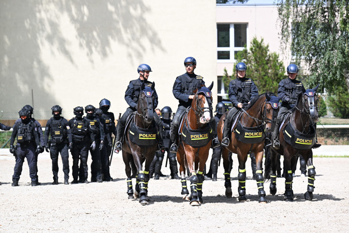 Policisté na koních a těžkooděnci.