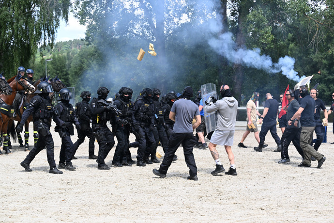 Policejní těžkoooděnci cvičně rozhánějí demonstranty.