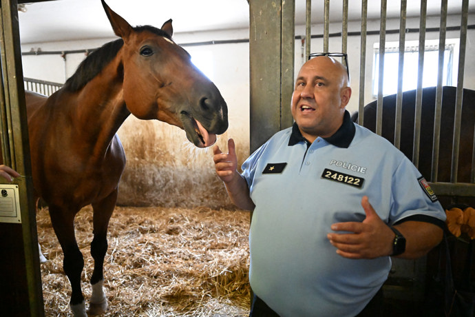Policista ukazuje policejní stáje.