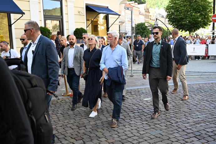 Lidé prezidentskému párů tleskají.