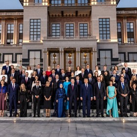 Setkání lídrů na summitu NATO. Zatímco Babiš s Monikou stojí zcela nalevo ve druhé řadě, prezident Pavel stojí zcela vpravo ve druhé řadě.