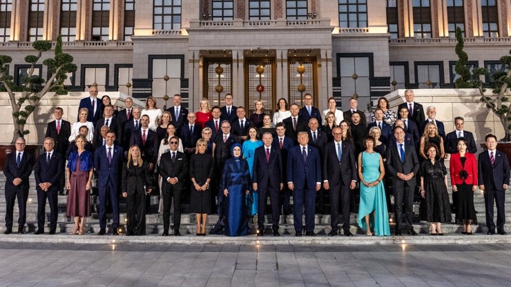 Setkání lídrů na summitu NATO. Zatímco Babiš s Monikou stojí zcela nalevo ve druhé řadě, prezident Pavel stojí zcela vpravo ve druhé řadě.
