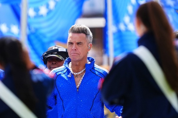 Zpěvák Robbie Williams byl v zářivě modré soupravě.