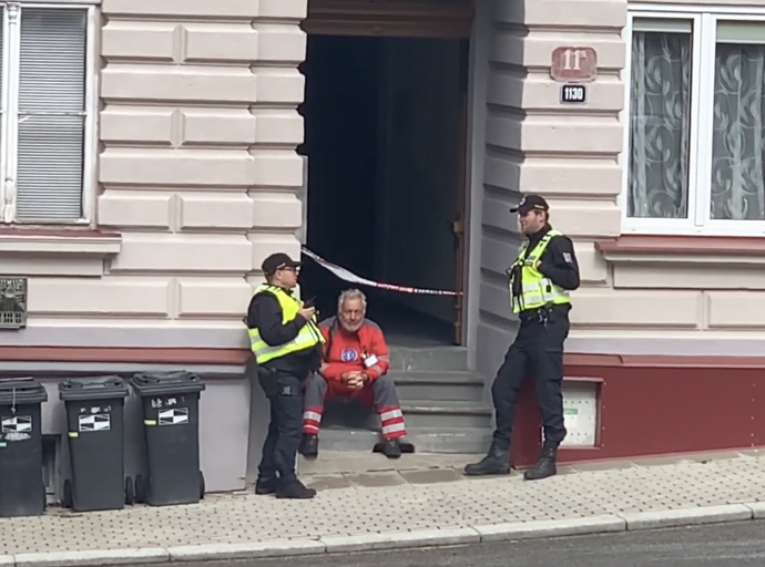 Záchranář sedící na schodech bytového domu byl po zásahu viditelně otřesený.