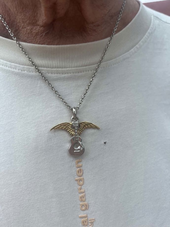 Přívěsek s okřídlenou kytarou byl původně dárek od kamaráda z Colorada. 
