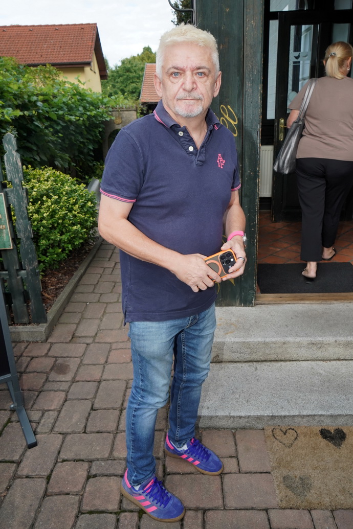 Michal Suchánek nosí tmavě modré polo tričko a džíny.