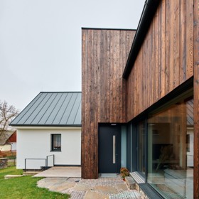 Obyčejný venkovský domek se stodolou proměnili architekti v moderní stavbu s opalovanou fasádou. Na chalupu sem jezdí tři generace jedné rodiny  