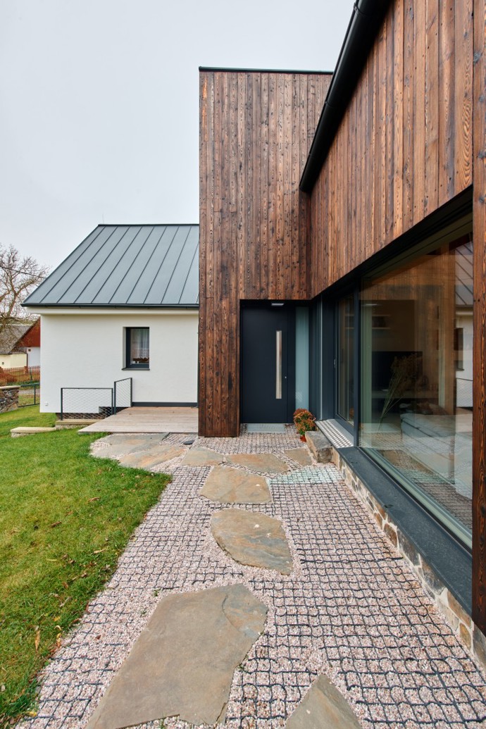 Obyčejný venkovský domek se stodolou proměnili architekti v moderní stavbu s opalovanou fasádou. Na chalupu sem jezdí tři generace jedné rodiny Obyčejný venkovský domek se stodolou proměnili architekti v moderní stavbu s opalovanou fasádou. Na chalupu sem jezdí tři generace jedné rodiny