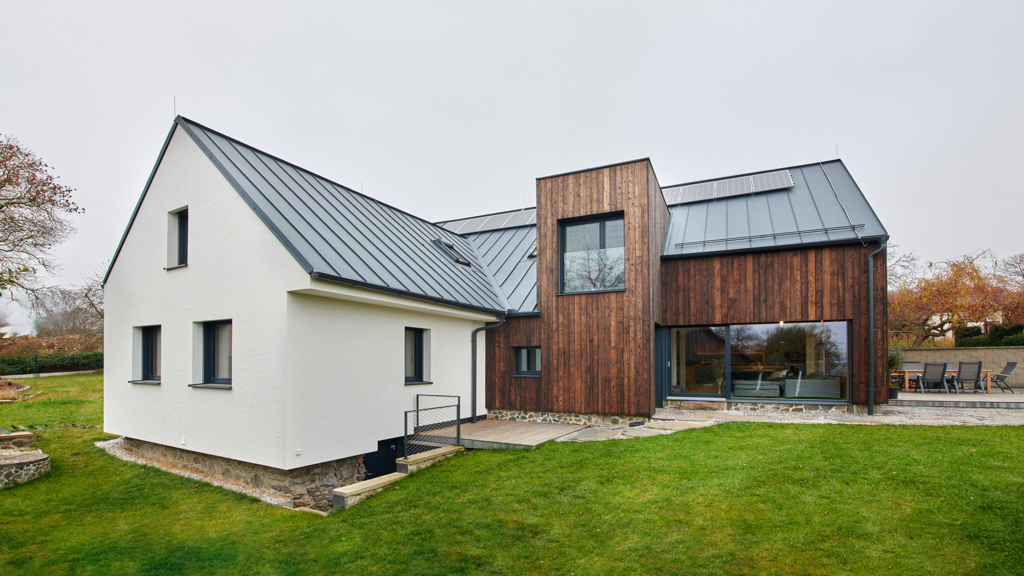 Obyčejný venkovský domek se stodolou proměnili architekti v moderní stavbu s opalovanou fasádou. Na chalupu sem jezdí tři generace jedné rodiny 