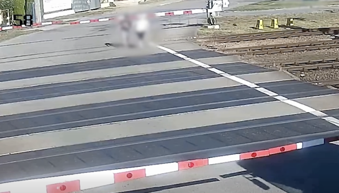 Dva muži se vydali přes železniční přejezd, i když byly dole závory a blikala červená světla.