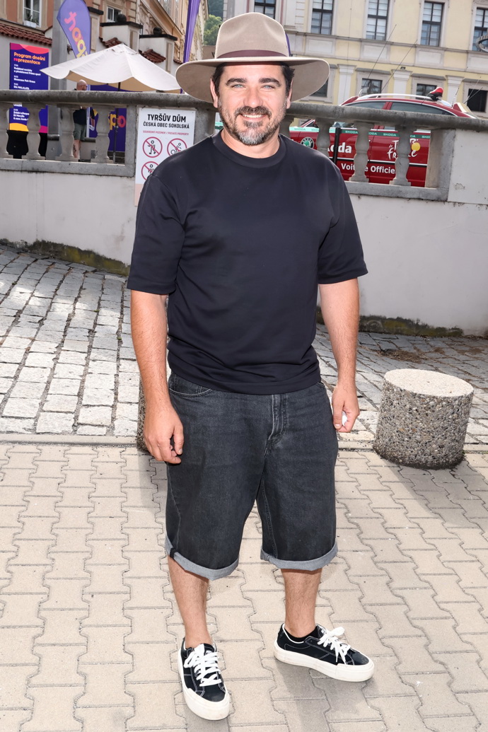 Vojta Kotek neodložil svůj milovaný klobouk a oblékl tmavě modré triko s krátkým rukávem a džínové kraťasy. 