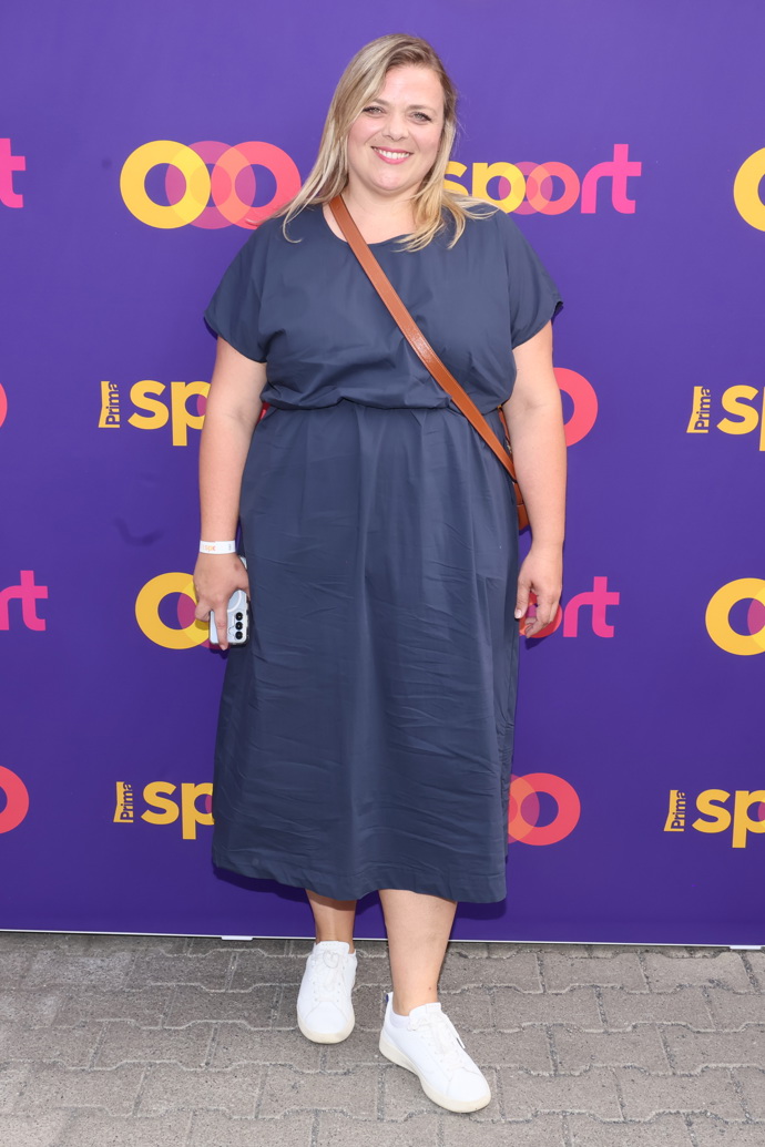 Lucie Polišenská oblékla tmavě modré šaty doplněné o hnědou crossbody kabelku a bílé tenisky.
