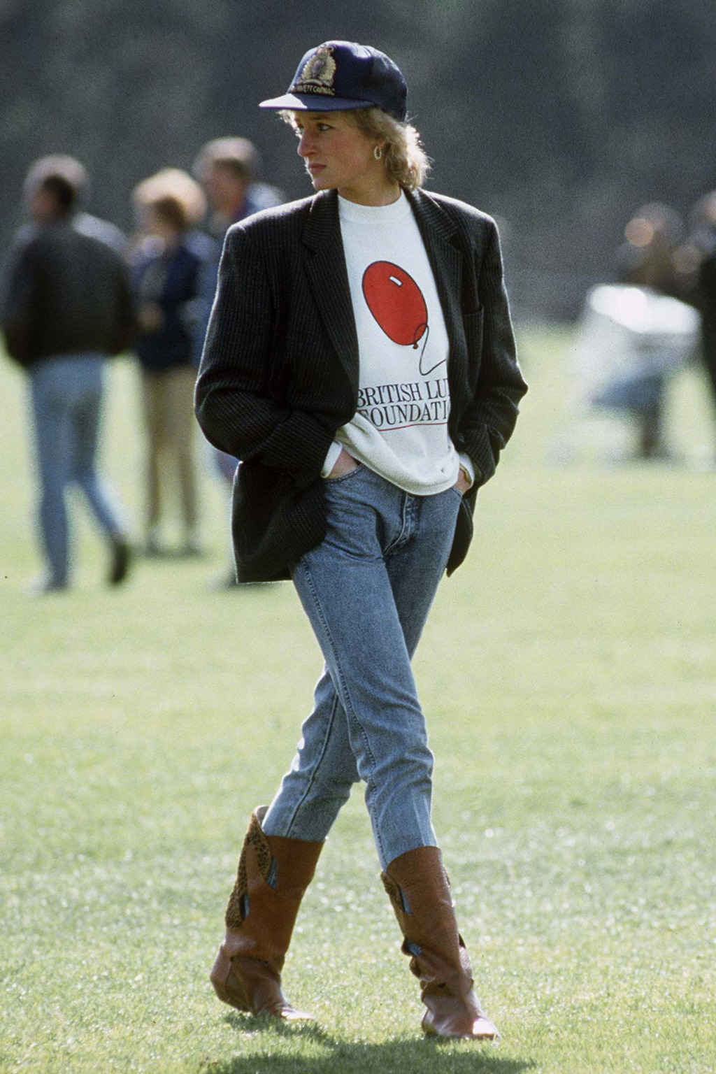 Princezna z Walesu zachycena v Guards Polo Club. Zde v jednom z nejikoničtějších outfitů, které kdy předvedla – v mikině s logem The British Lung Foundation, oversize saku, denimových kalhotách zastrčených v kožených kovbojských botách a s baseballovou kšiltovkou na hlavě.
Princezna z Walesu zachycena v Guards Polo Club. Zde v jednom z nejikoničtějších outfitů, které kdy předvedla – v mikině s logem The British Lung Foundation, oversize saku, denimových kalhotách zastrčených v kožených kovbojských botách a s baseballovou kšiltovkou na hlavě.