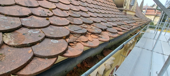 Detail původní krytiny před rekonstrukcí ukazuje popraskané a zvětralé tašky, pod nimiž už střecha přestávala spolehlivě chránit historické interiéry
