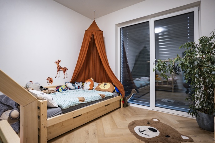 Dětský pokoj působí hravě díky dřevěné posteli, baldachýnu a motivům lesních zvířat